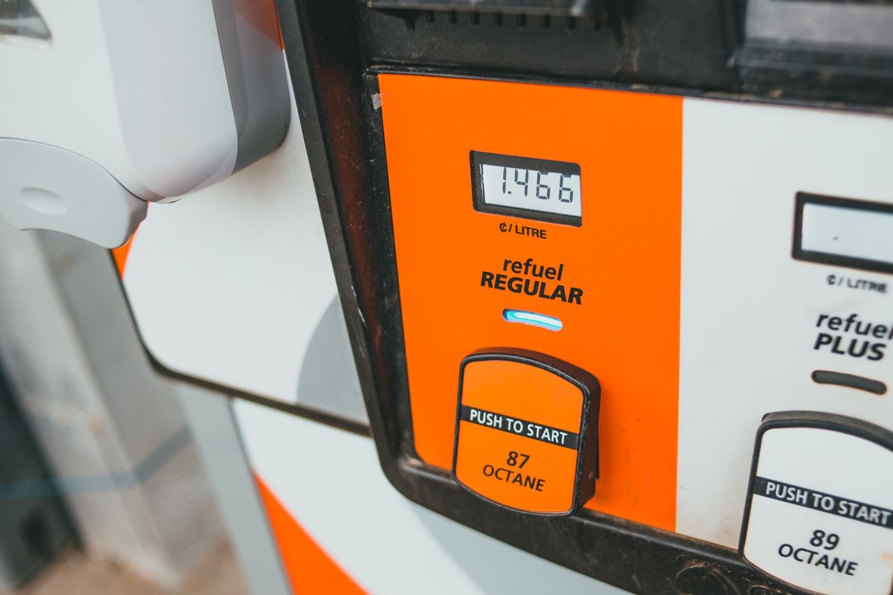 Detalhe de uma bomba de combustível exibindo o preço e a octanagem da gasolina.